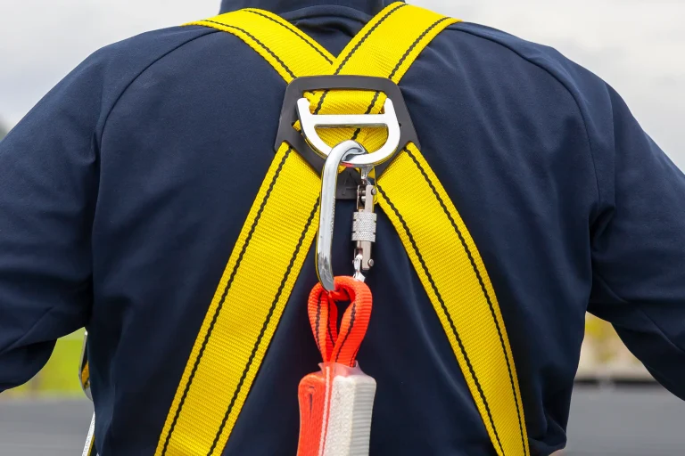 Worker in safety harness for roof cleaning